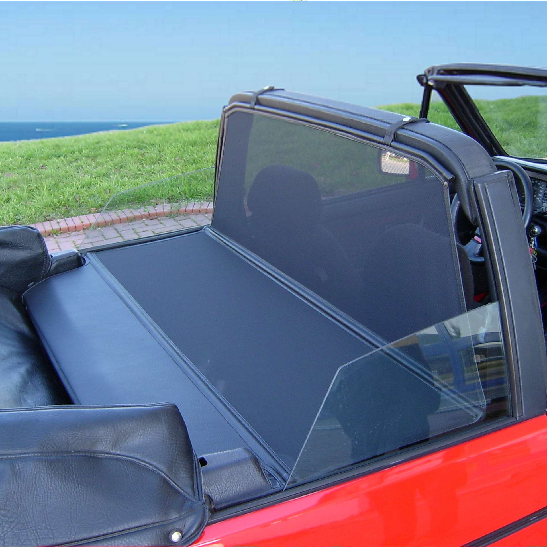 a red vw golf 1 convertible with a bodi xl wind deflector