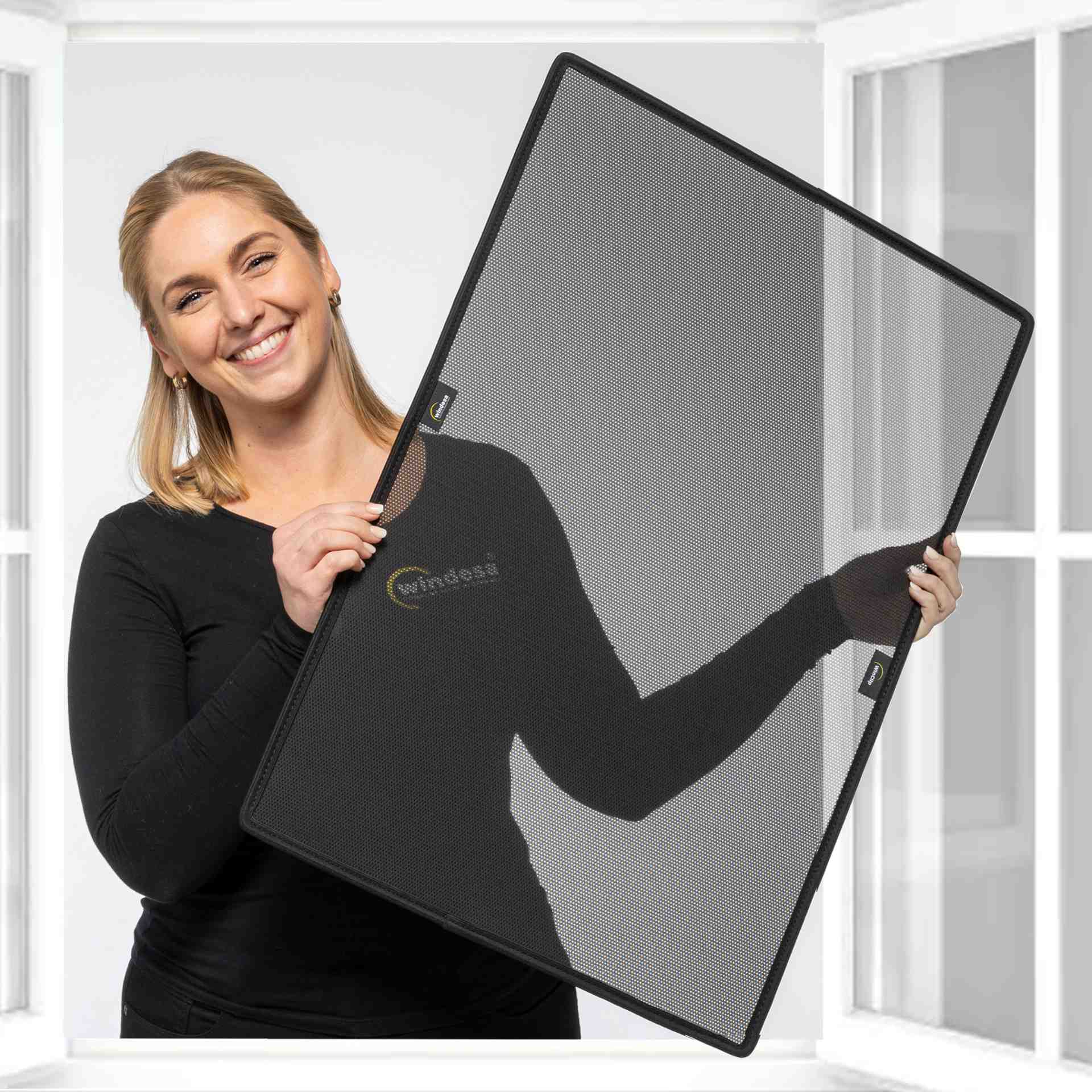 eine Frau hält lächelnd einen WinClip vor ein Kunststofffenster