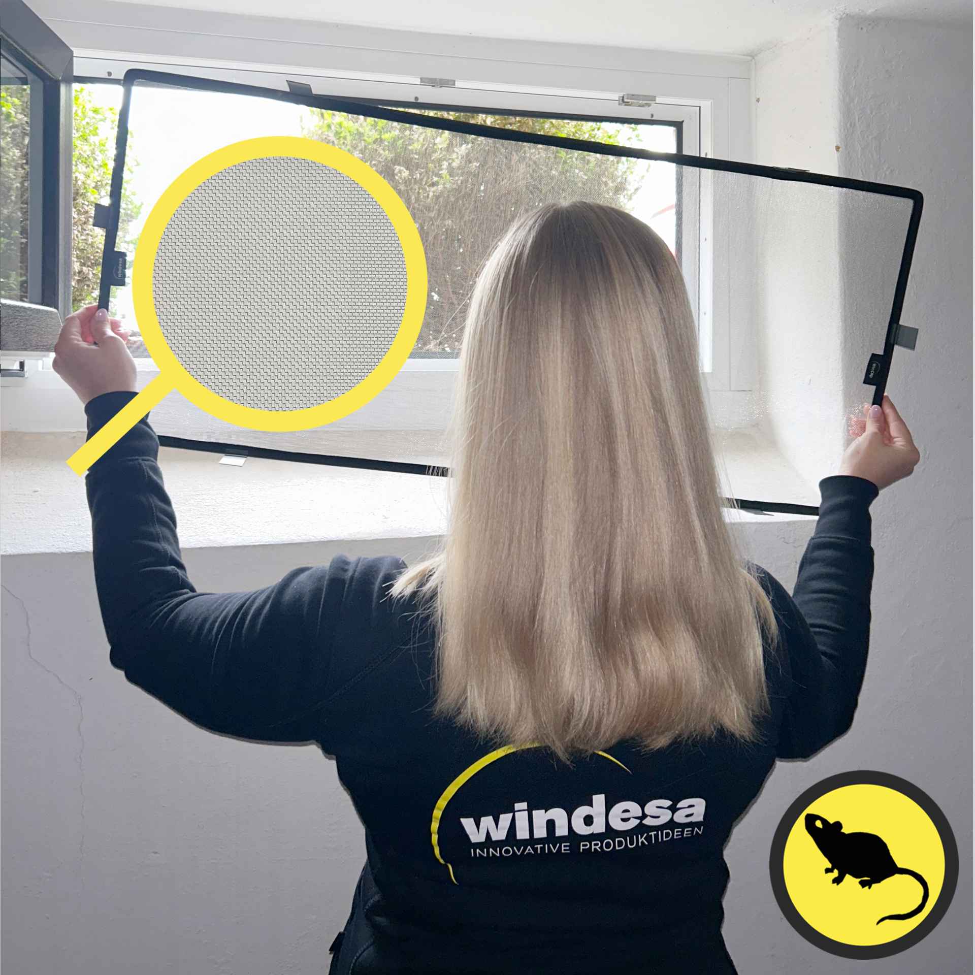A woman installs the WinClip on a basement window