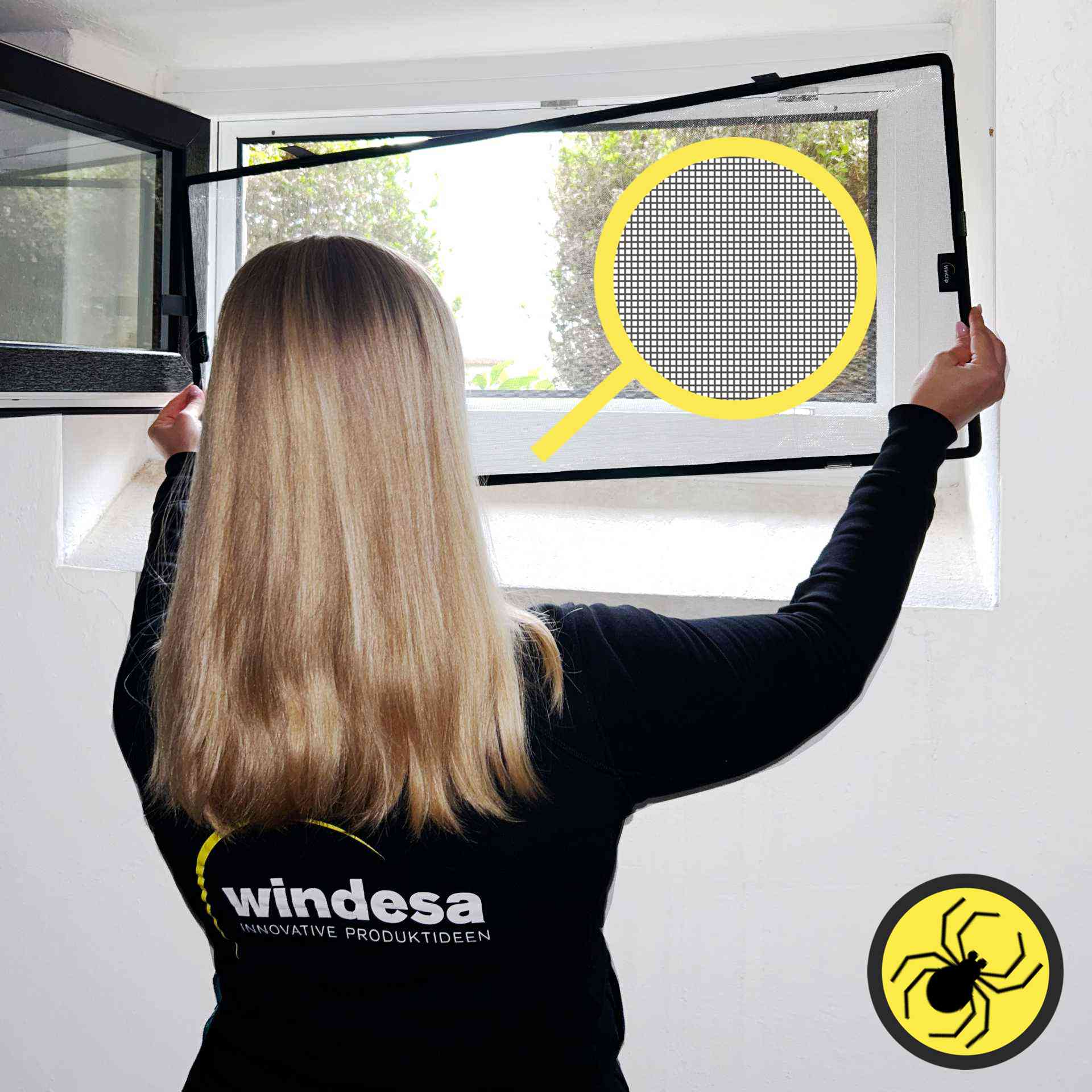 eine Frau hält einen WinClip Spider an ein Kellerfenster
