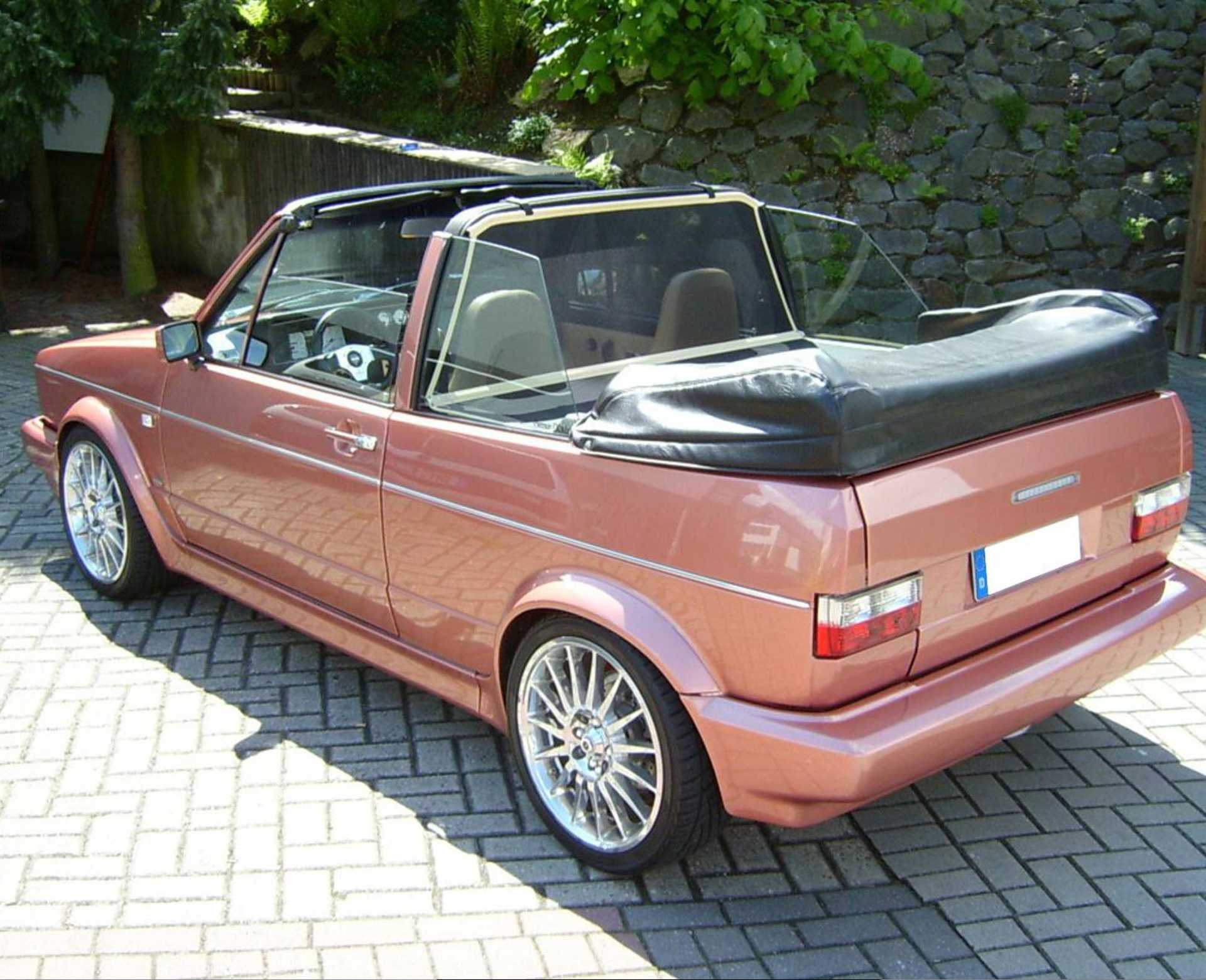 a red vw golf 1 convertible with a bodi wind deflector