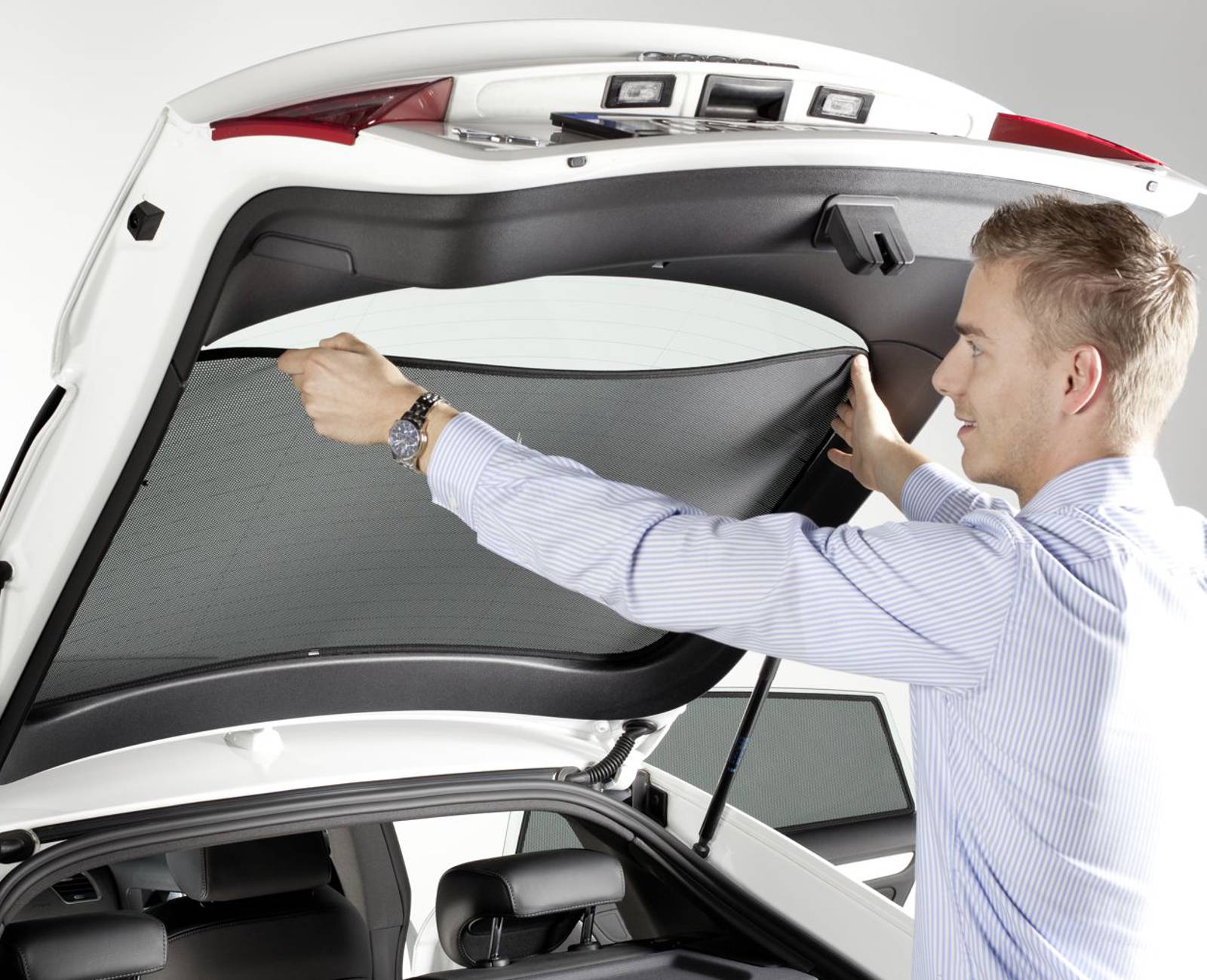 ein Mann installiert einen SunClip an die Heckscheibe eines Autos